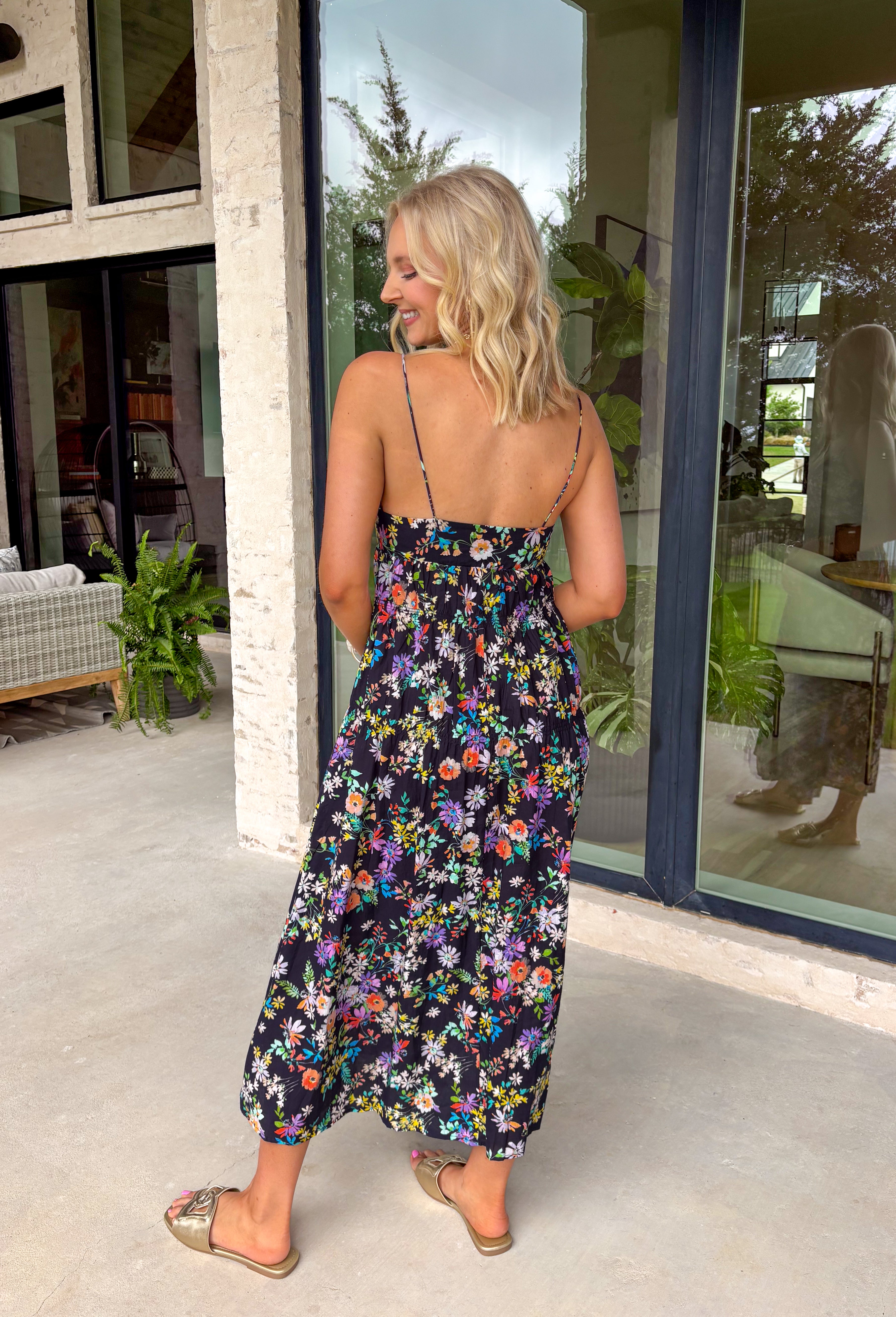 Easy, colorful, and perfect for spring days, this black sleeveless midi dress by Lovestitch is a standout piece you’ll love all season long. Featuring a vibrant floral print with pops of purple, orange, yellow, blue, and pink, this dress brings just the right amount of color to a classic silhouette. The front button details and elastic waist create a flattering, comfortable fit that’s ideal for everything from brunch dates to weekend outings.