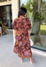 Warm fall color takes center stage in this terra cotta floral midi dress from Entro. Covered in a beautiful floral print featuring shades of the season, it has an autumn-ready look that works for everything from family photos to weekend gatherings. The v-neckline and button-front closure keep the silhouette classic, while short puff sleeves add a sweet touch of volume.