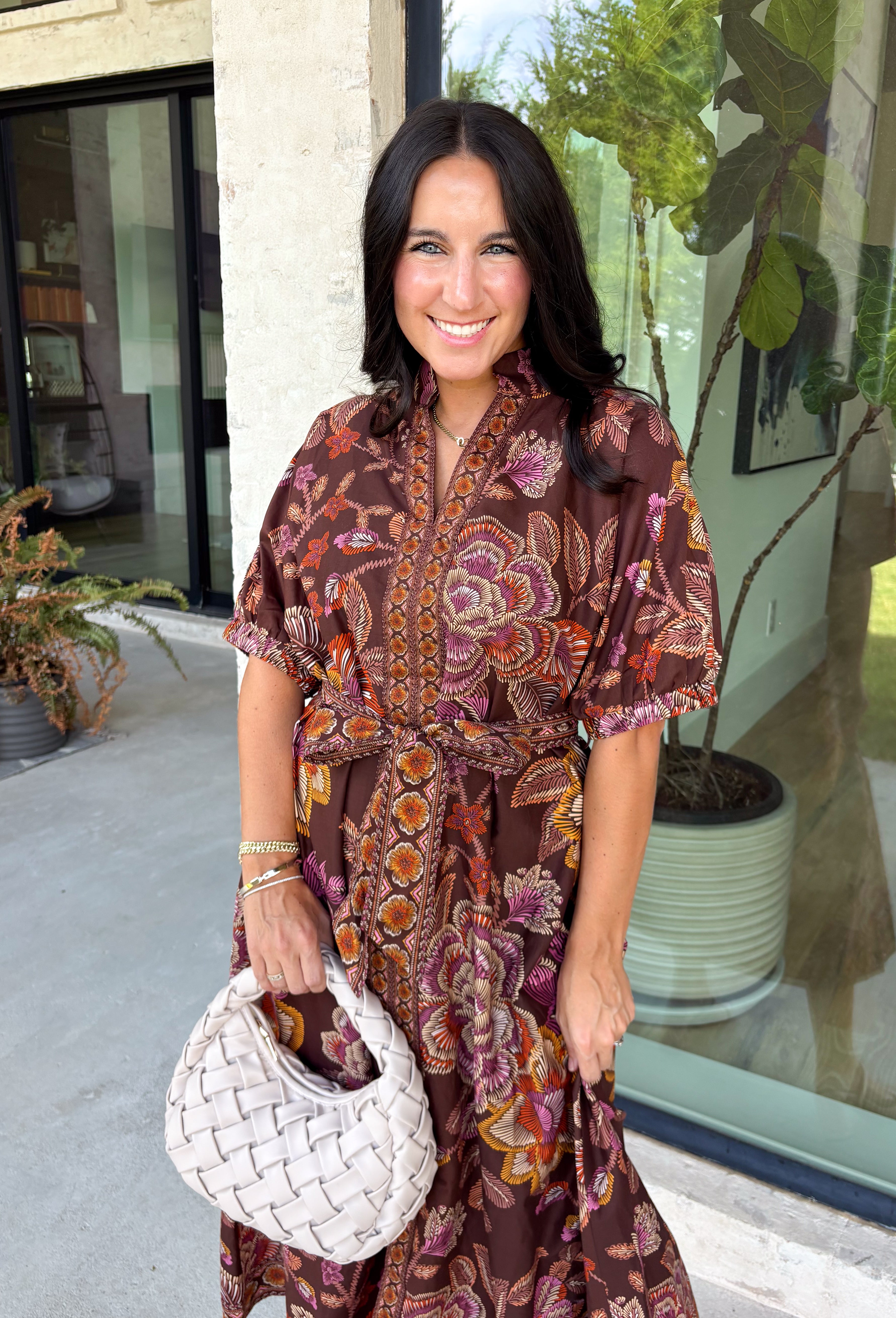 Warm fall color takes center stage in this terra cotta floral midi dress from Entro. Covered in a beautiful floral print featuring shades of the season, it has an autumn-ready look that works for everything from family photos to weekend gatherings. The v-neckline and button-front closure keep the silhouette classic, while short puff sleeves add a sweet touch of volume.