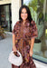 Warm fall color takes center stage in this terra cotta floral midi dress from Entro. Covered in a beautiful floral print featuring shades of the season, it has an autumn-ready look that works for everything from family photos to weekend gatherings. The v-neckline and button-front closure keep the silhouette classic, while short puff sleeves add a sweet touch of volume.