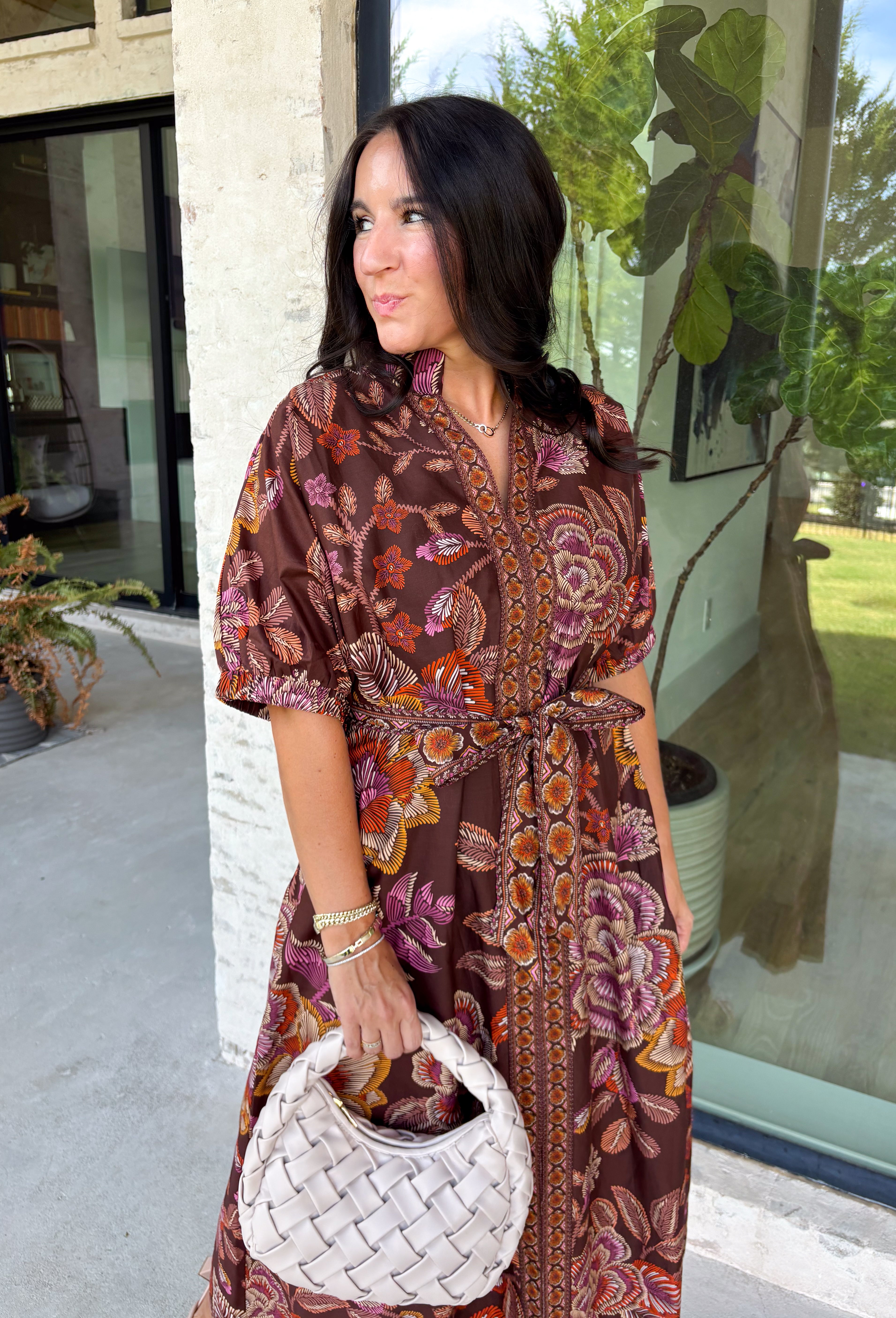 Warm fall color takes center stage in this terra cotta floral midi dress from Entro. Covered in a beautiful floral print featuring shades of the season, it has an autumn-ready look that works for everything from family photos to weekend gatherings. The v-neckline and button-front closure keep the silhouette classic, while short puff sleeves add a sweet touch of volume.