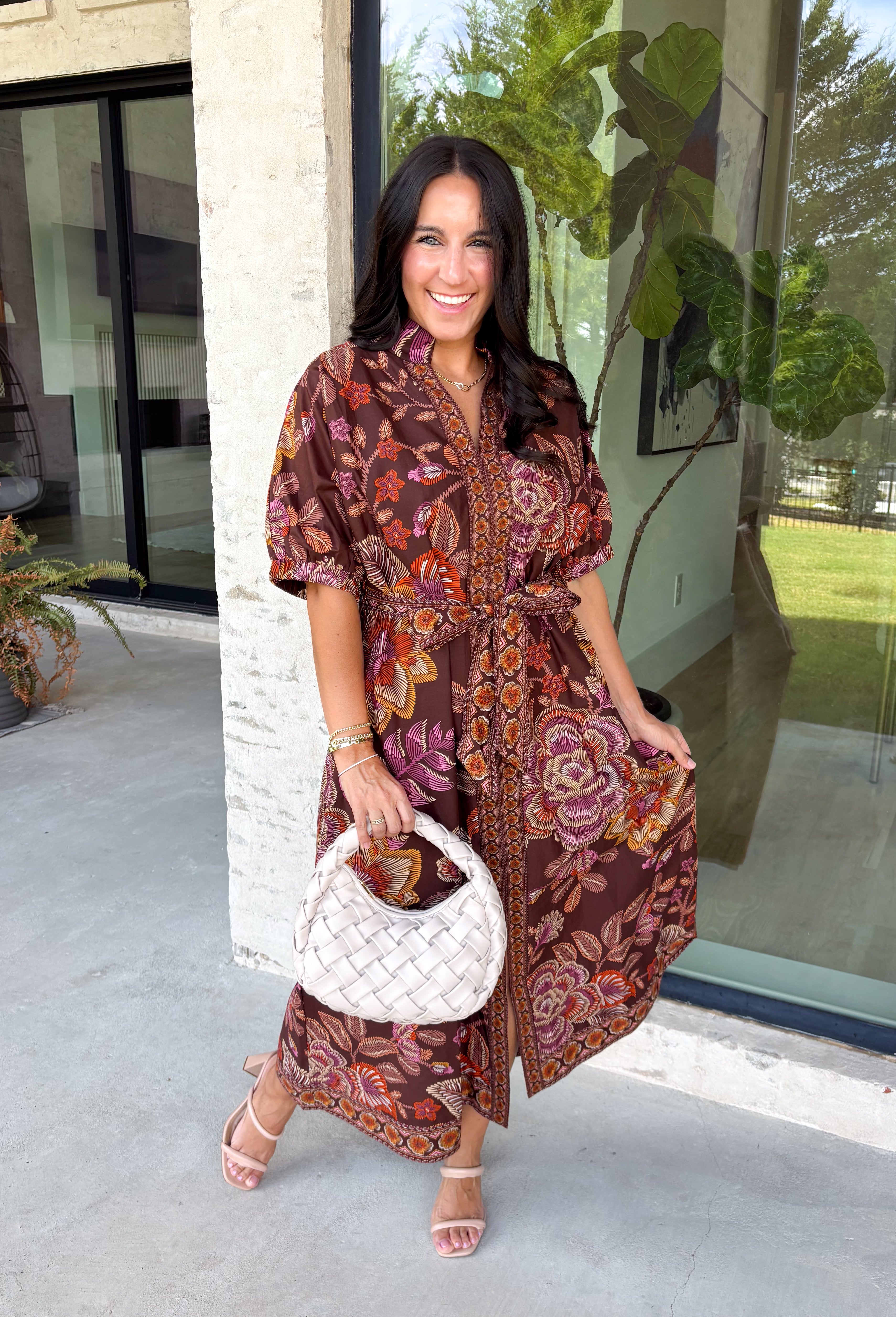 Warm fall color takes center stage in this terra cotta floral midi dress from Entro. Covered in a beautiful floral print featuring shades of the season, it has an autumn-ready look that works for everything from family photos to weekend gatherings. The v-neckline and button-front closure keep the silhouette classic, while short puff sleeves add a sweet touch of volume.