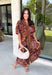 Warm fall color takes center stage in this terra cotta floral midi dress from Entro. Covered in a beautiful floral print featuring shades of the season, it has an autumn-ready look that works for everything from family photos to weekend gatherings. The v-neckline and button-front closure keep the silhouette classic, while short puff sleeves add a sweet touch of volume.