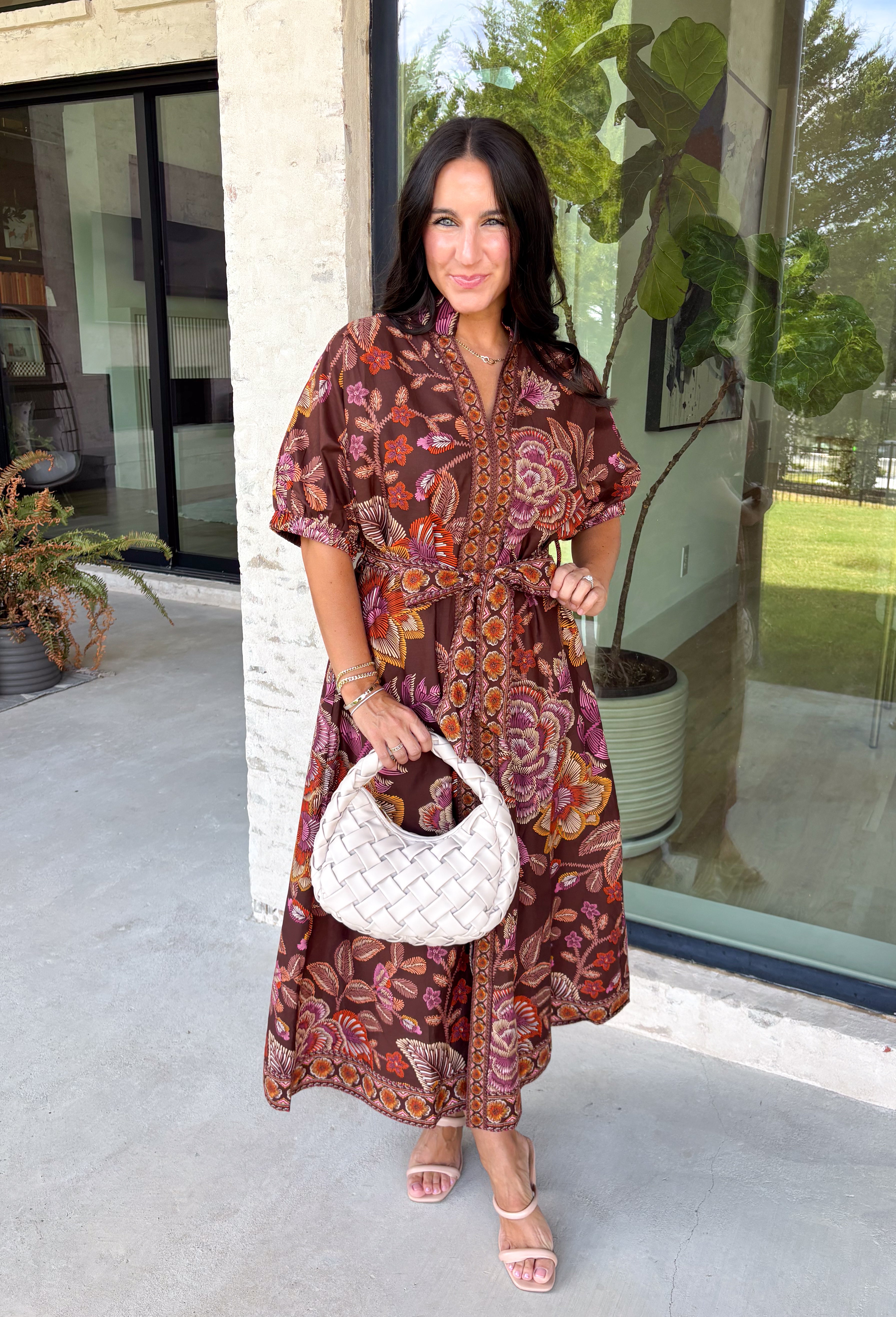 Warm fall color takes center stage in this terra cotta floral midi dress from Entro. Covered in a beautiful floral print featuring shades of the season, it has an autumn-ready look that works for everything from family photos to weekend gatherings. The v-neckline and button-front closure keep the silhouette classic, while short puff sleeves add a sweet touch of volume.