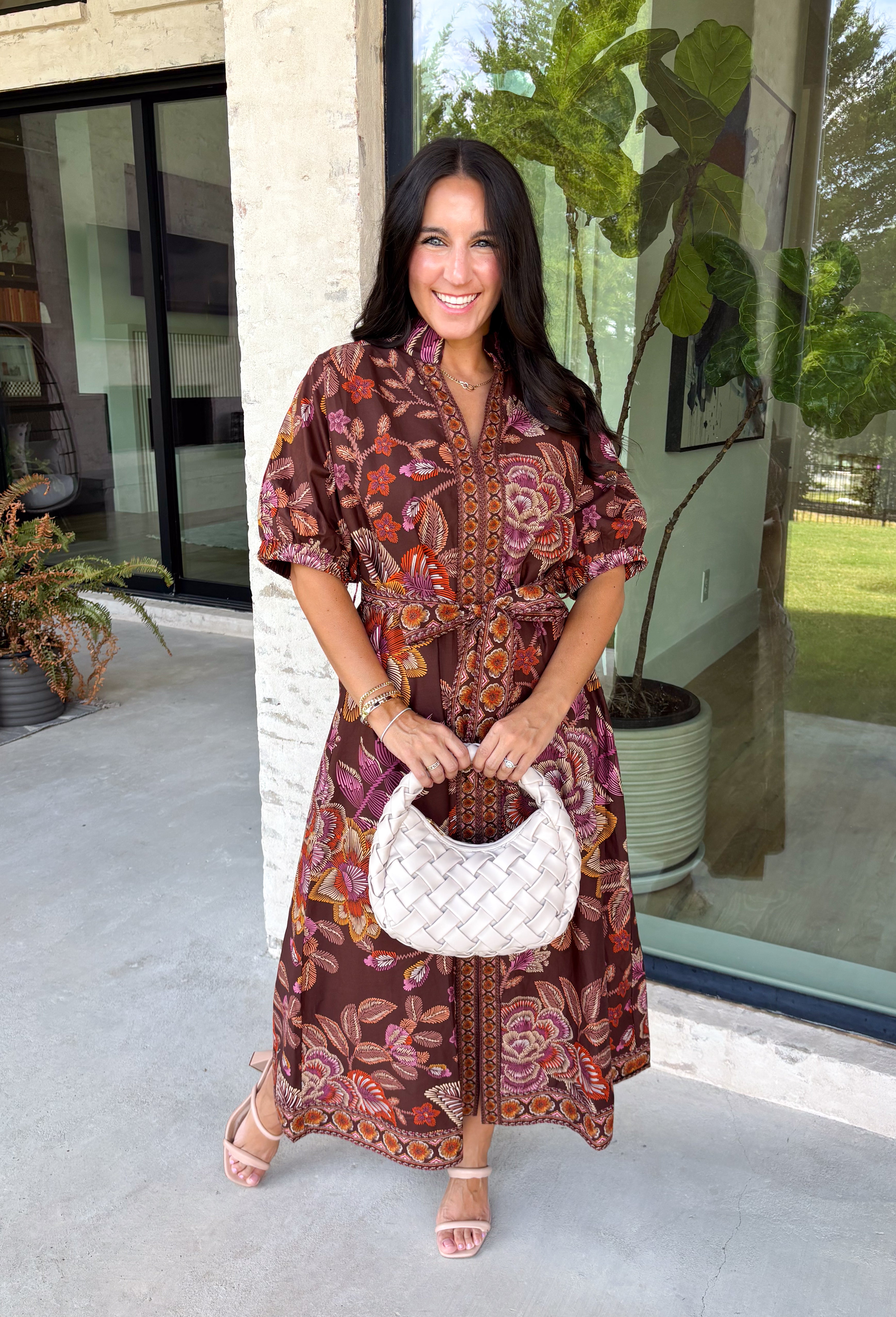 Warm fall color takes center stage in this terra cotta floral midi dress from Entro. Covered in a beautiful floral print featuring shades of the season, it has an autumn-ready look that works for everything from family photos to weekend gatherings. The v-neckline and button-front closure keep the silhouette classic, while short puff sleeves add a sweet touch of volume.