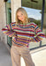 Wrap yourself in all the beautiful colors of the season with this cozy striped sweater. Featuring a gorgeous mix of green, off white, rust, blue, brown, purple, and yellow, this soft knit brings warmth, personality, and effortless style to your everyday wardrobe. The relaxed silhouette makes it perfect for layering on crisp fall mornings or cozy evenings, while the colorful stripes make it an easy statement piece you'll love wearing year after year. 