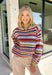 Wrap yourself in all the beautiful colors of the season with this cozy striped sweater. Featuring a gorgeous mix of green, off white, rust, blue, brown, purple, and yellow, this soft knit brings warmth, personality, and effortless style to your everyday wardrobe. The relaxed silhouette makes it perfect for layering on crisp fall mornings or cozy evenings, while the colorful stripes make it an easy statement piece you'll love wearing year after year. 