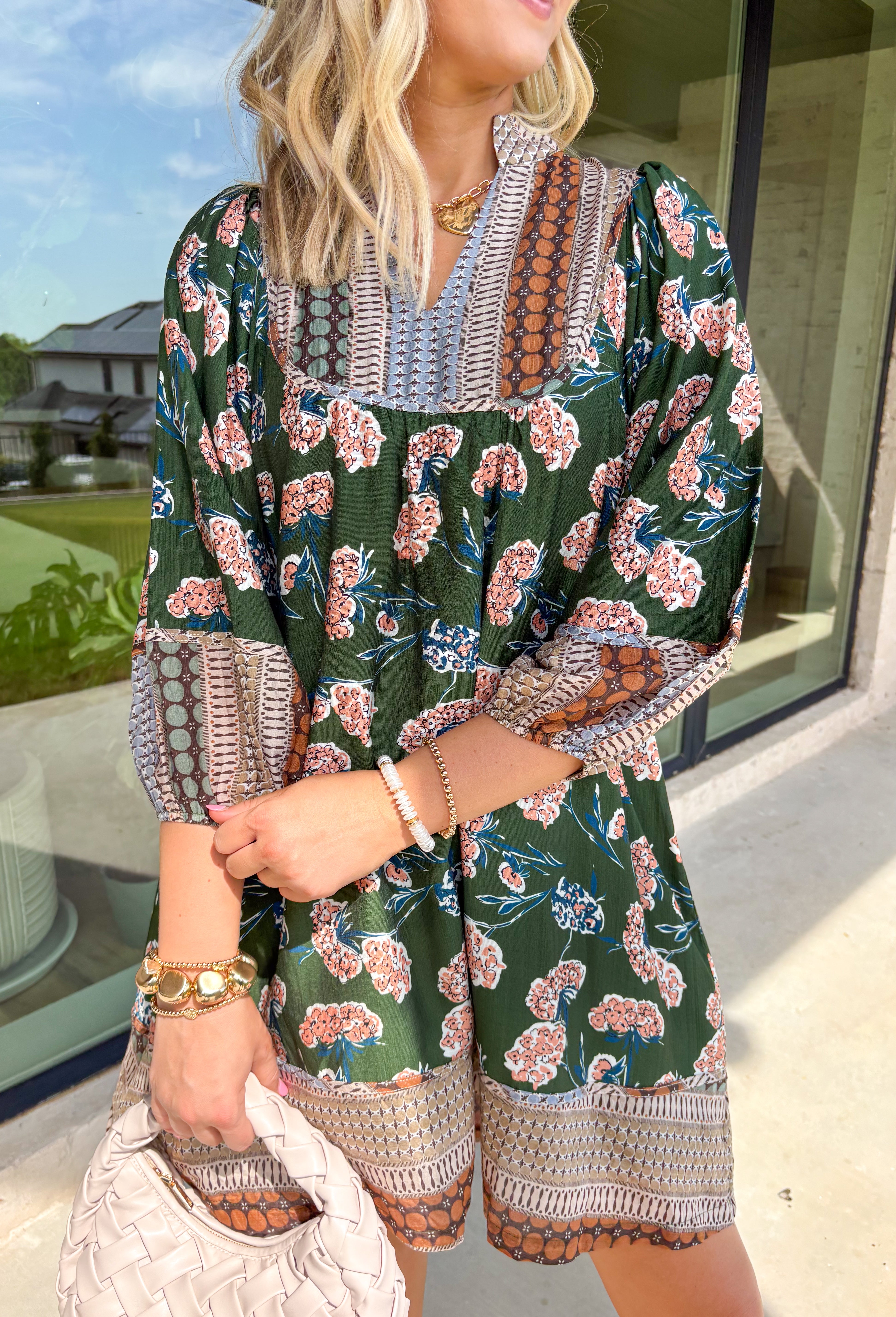 Bring a rich fall palette into your wardrobe with this dark green dress, designed with a mix of seasonal florals. Trimmed in an abstract print along the neckline, hemline, and sleeves, it has an artisan-inspired finish that feels unique and thoughtful. The elastic cuff sleeves add comfort and a touch of volume, while the flowy silhouette and full lining keep it easy to wear from day to night. Accented with shades of brown, this dress is a cozy yet elevated choice for the season.