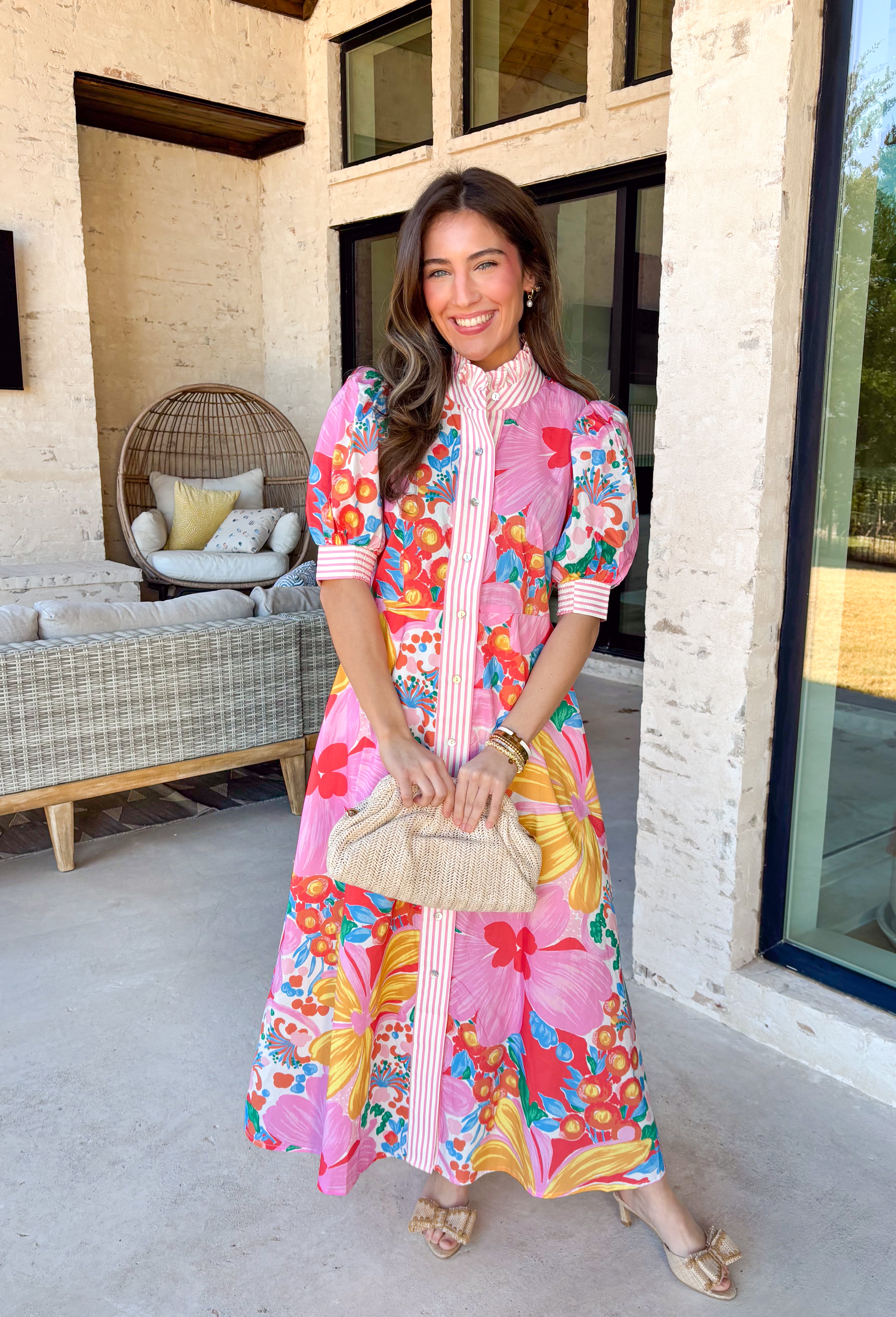 Bright, joyful, and bursting with spring color, this white short sleeve button-down dress by Entro is a total showstopper. Featuring a bold floral print in pink, red, blue, yellow, green, and orange, it brings instant happy vibes to your wardrobe. The ruffle neckline is trimmed with pink and white stripes for a fun pop of contrast, with matching stripe detail running down the front and along the sleeve cuffs. Smocking at the back of the sleeves adds comfort and shape, while side pockets and a lining make it