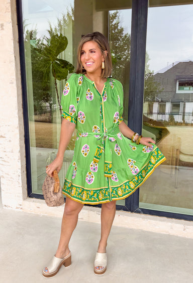 Bring a burst of sunshine to your spring wardrobe with this lime green dress. The lively floral print features playful pops of lilac, green, and white, while the contrasting hem in green, mustard, and white adds a fun, unexpected twist. The button-down front and self-tie belt create a flattering, adjustable fit, and the lightweight fabric keeps it breezy for warm spring days. Whether you’re headed to brunch or strolling the farmers’ market, this dress is all about easy, cheerful style.