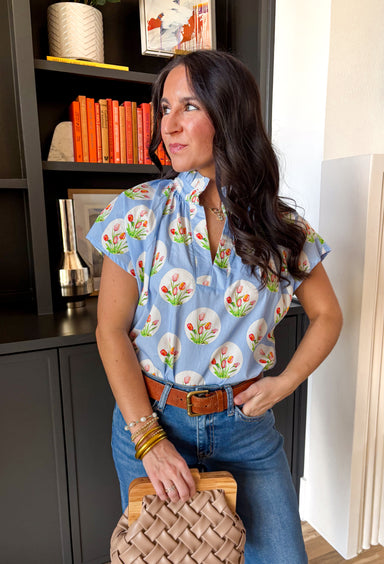 This light blue beauty is giving us all the cheerful spring vibes. Covered in classic white polka dots with the sweetest colorful tulip print tucked inside each one, this top feels playful, fresh, and full of personality. The subtle ruffle neckline and flattering v-neckline add just the right feminine touch, making it an easy pick for sunny days, weekend brunch, and everything in between.