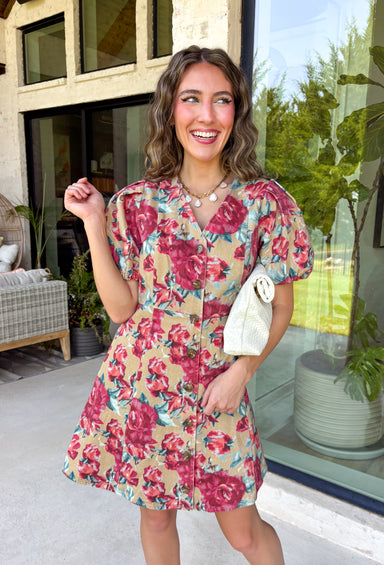 Fall florals meet everyday comfort in this effortlessly charming dress. Crafted from soft camel denim, this beautiful dress features a colorful floral print with rich burgundy and teal blooms that add the perfect pop of seasonal color. The flattering v-neckline and button-front design create a timeless silhouette, while the back elastic waist offers a comfortable, easy fit. 