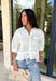 Crisp, classic, and perfect for spring styling, this white short sleeve button-down top by Entro is an easy closet staple with a sweet twist. The structured button-front design keeps it polished, while the ruffle hem adds a soft, feminine touch that elevates the look. Finished with a chest pocket and buttoned sleeve cuffs, this top is lightweight, versatile, and effortless to dress up or down for the season.