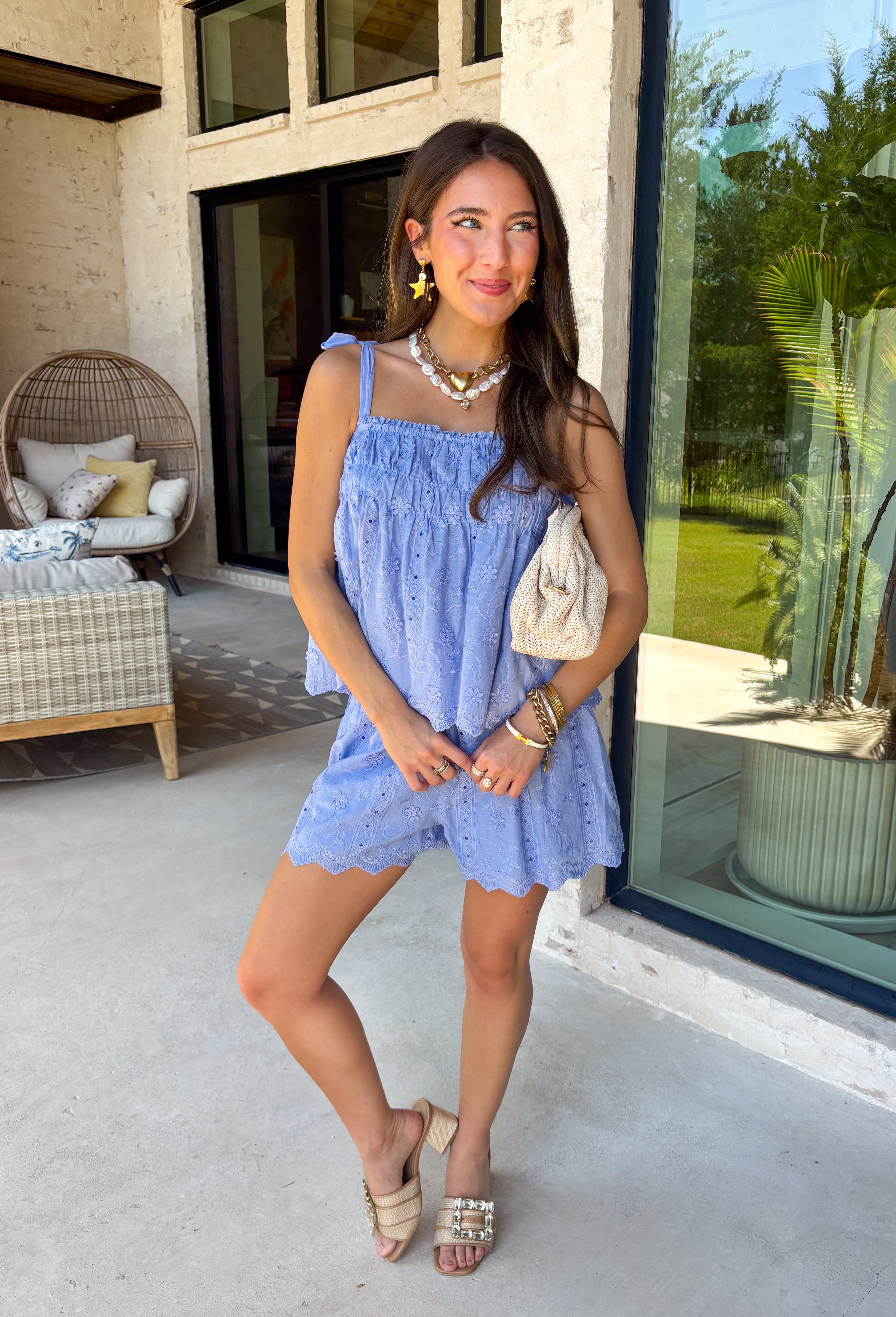 This light blue eyelet lace set is the definition of a dreamy summer outfit! The delicate eyelet detail paired with scalloped hems gives it that soft, feminine feel, while the matching set makes getting dressed effortless. The sleeveless top features smocking along the front and adjustable tie straps for the perfect fit, and the elastic waist shorts keep things comfortable for all-day wear. Lightweight and breathable in 100% cotton, it’s perfect for everything from vacation mornings to casual days out