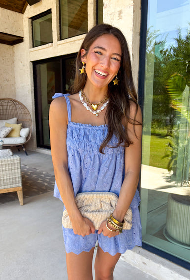 This light blue eyelet lace set is the definition of a dreamy summer outfit! The delicate eyelet detail paired with scalloped hems gives it that soft, feminine feel, while the matching set makes getting dressed effortless. The sleeveless top features smocking along the front and adjustable tie straps for the perfect fit, and the elastic waist shorts keep things comfortable for all-day wear. Lightweight and breathable in 100% cotton, it’s perfect for everything from vacation mornings to casual days out