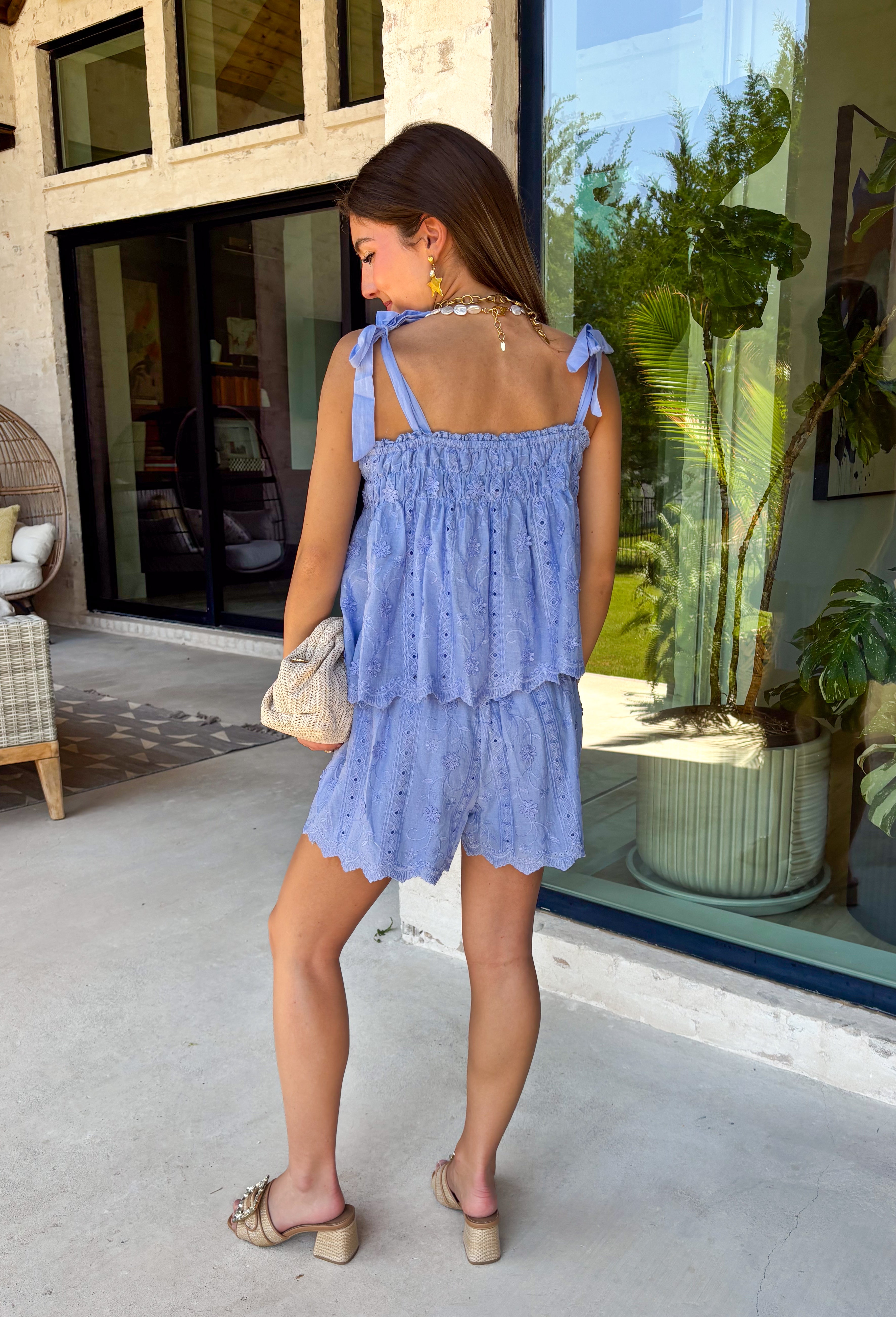 This light blue eyelet lace set is the definition of a dreamy summer outfit! The delicate eyelet detail paired with scalloped hems gives it that soft, feminine feel, while the matching set makes getting dressed effortless. The sleeveless top features smocking along the front and adjustable tie straps for the perfect fit, and the elastic waist shorts keep things comfortable for all-day wear. Lightweight and breathable in 100% cotton, it’s perfect for everything from vacation mornings to casual days out