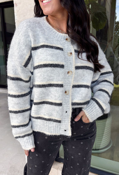 Cozy up in timeless style with this beautiful cardigan from Hyfve. Designed in a soft light gray knit with classic black and cream stripes, this button-down sweater is the perfect layering piece for the season. Ribbed detailing throughout adds texture and a polished finish, while the ultra-soft knit blend keeps you warm and comfortable without feeling bulky. Whether you wear it buttoned as a sweater or layered over your favorite basics, this versatile cardigan is one you'll reach for again and again.