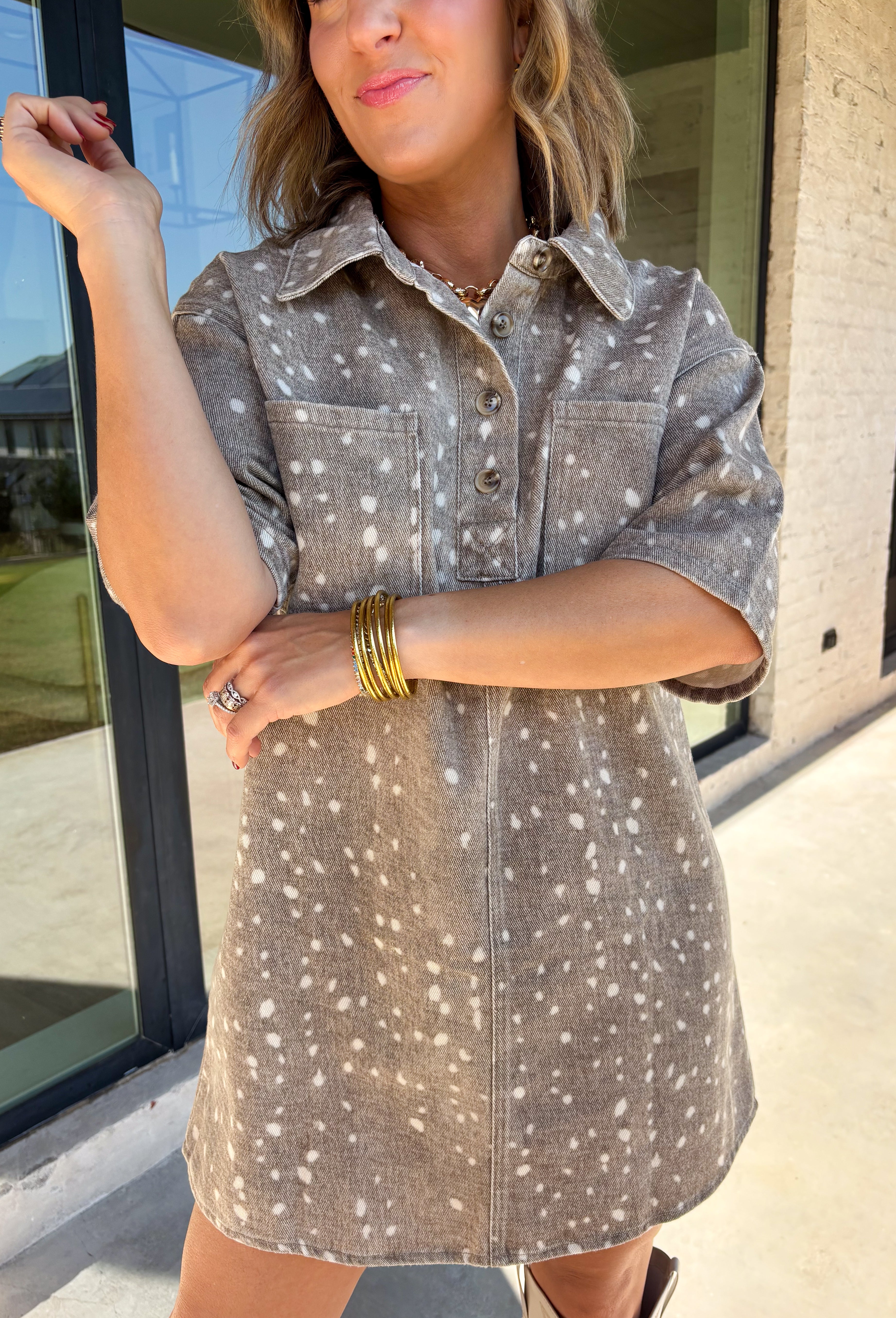 Take a walk on the playful side of fall with this mocha denim dress from New In. The warm mocha shade is covered in an ivory fawn-inspired spotted print, giving classic denim an unexpected woodland twist that’s perfect for the season. A collared neckline and front button closure keep the silhouette classic, while short sleeves make it a great pick for warmer autumn afternoons. Front pockets add a casual, functional touch and complement the denim construction.