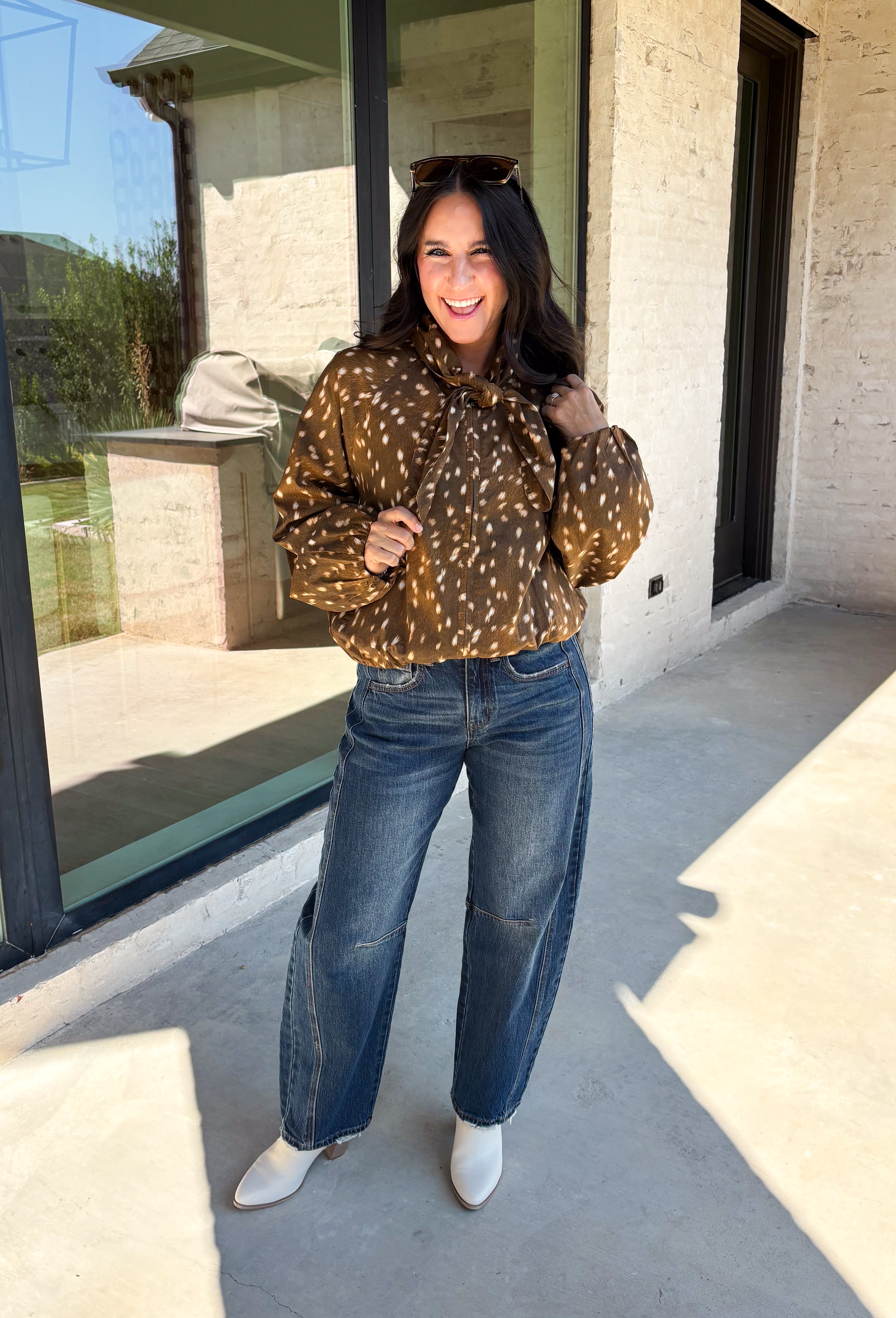 Give your fall layers a little personality with this brown animal print jacket from Entro. The neutral color palette makes the statement print surprisingly easy to mix into your everyday wardrobe, whether you're heading to lunch, running errands, or spending a Saturday out and about. A zipper closure keeps the silhouette casual, while the tie detail at the neckline adds a fun finishing touch.