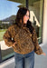 Give your fall layers a little personality with this brown animal print jacket from Entro. The neutral color palette makes the statement print surprisingly easy to mix into your everyday wardrobe, whether you're heading to lunch, running errands, or spending a Saturday out and about. A zipper closure keeps the silhouette casual, while the tie detail at the neckline adds a fun finishing touch.