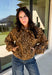Give your fall layers a little personality with this brown animal print jacket from Entro. The neutral color palette makes the statement print surprisingly easy to mix into your everyday wardrobe, whether you're heading to lunch, running errands, or spending a Saturday out and about. A zipper closure keeps the silhouette casual, while the tie detail at the neckline adds a fun finishing touch.