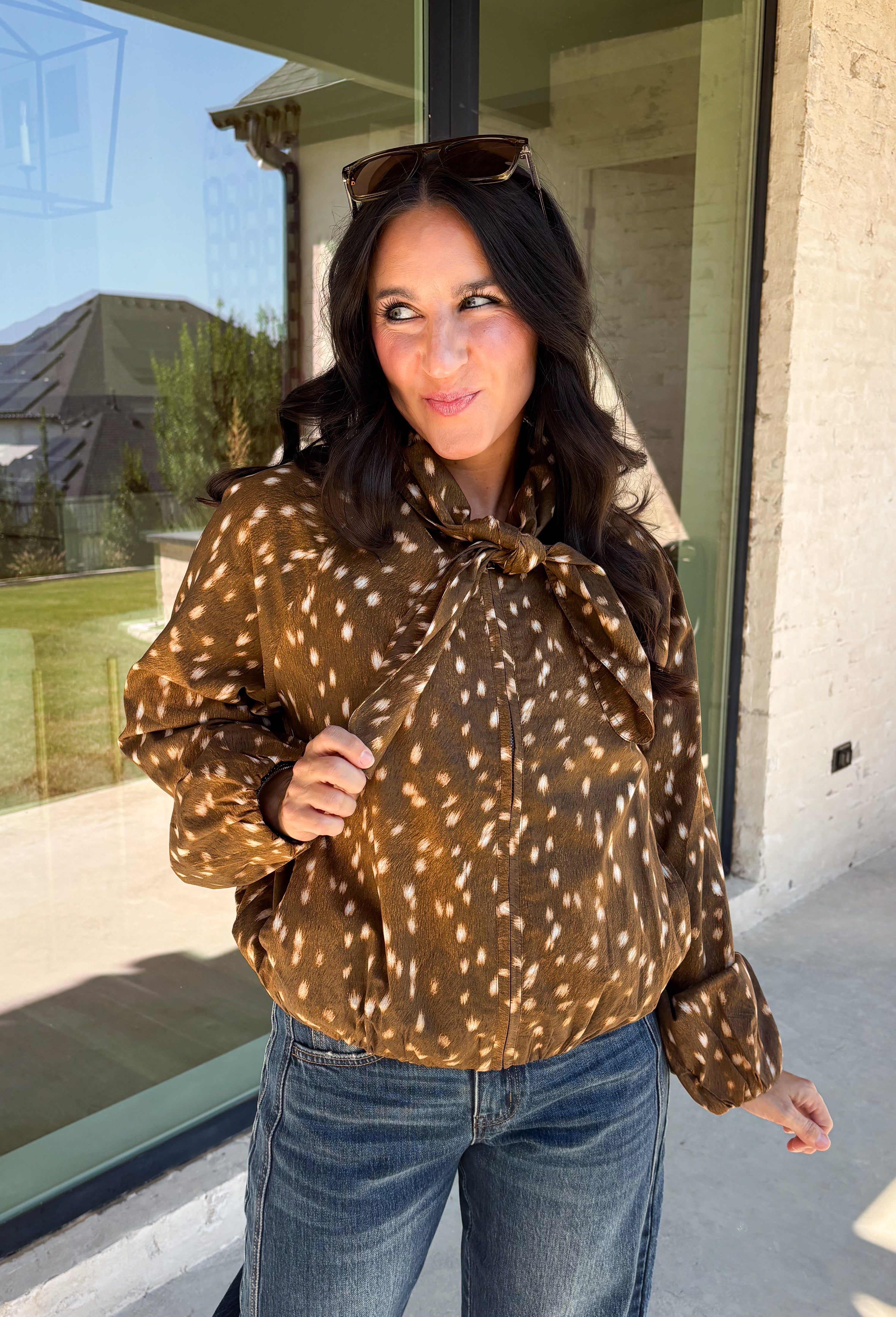 Give your fall layers a little personality with this brown animal print jacket from Entro. The neutral color palette makes the statement print surprisingly easy to mix into your everyday wardrobe, whether you're heading to lunch, running errands, or spending a Saturday out and about. A zipper closure keeps the silhouette casual, while the tie detail at the neckline adds a fun finishing touch.