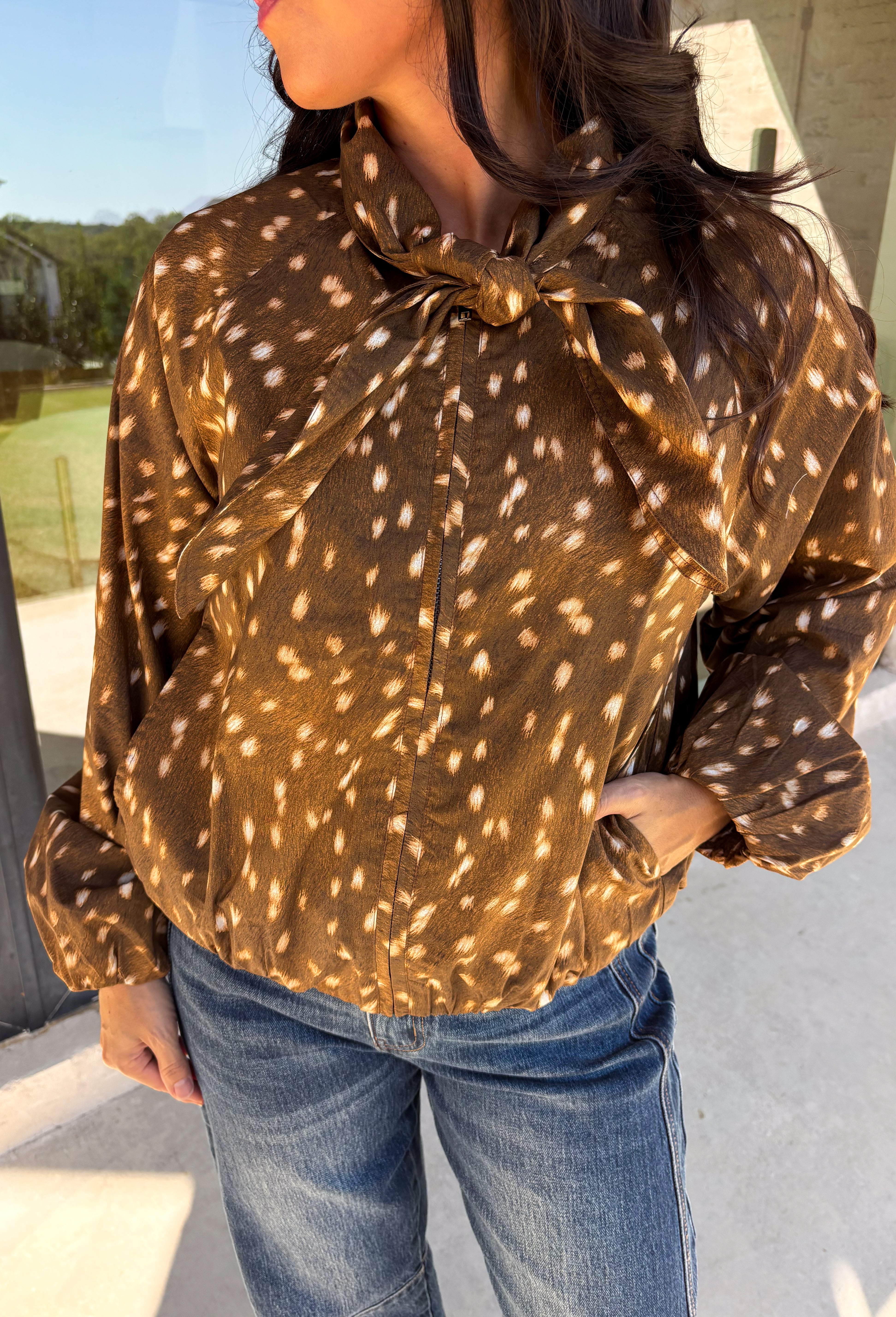 Give your fall layers a little personality with this brown animal print jacket from Entro. The neutral color palette makes the statement print surprisingly easy to mix into your everyday wardrobe, whether you're heading to lunch, running errands, or spending a Saturday out and about. A zipper closure keeps the silhouette casual, while the tie detail at the neckline adds a fun finishing touch.