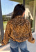 Give your fall layers a little personality with this brown animal print jacket from Entro. The neutral color palette makes the statement print surprisingly easy to mix into your everyday wardrobe, whether you're heading to lunch, running errands, or spending a Saturday out and about. A zipper closure keeps the silhouette casual, while the tie detail at the neckline adds a fun finishing touch.