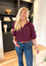 Best Effort Blouse in Merlot, quarter sleeve blouse with ruffle detail around the neck and on the shoulders, v-neck line, ruffling on the bottom of the sleeves 