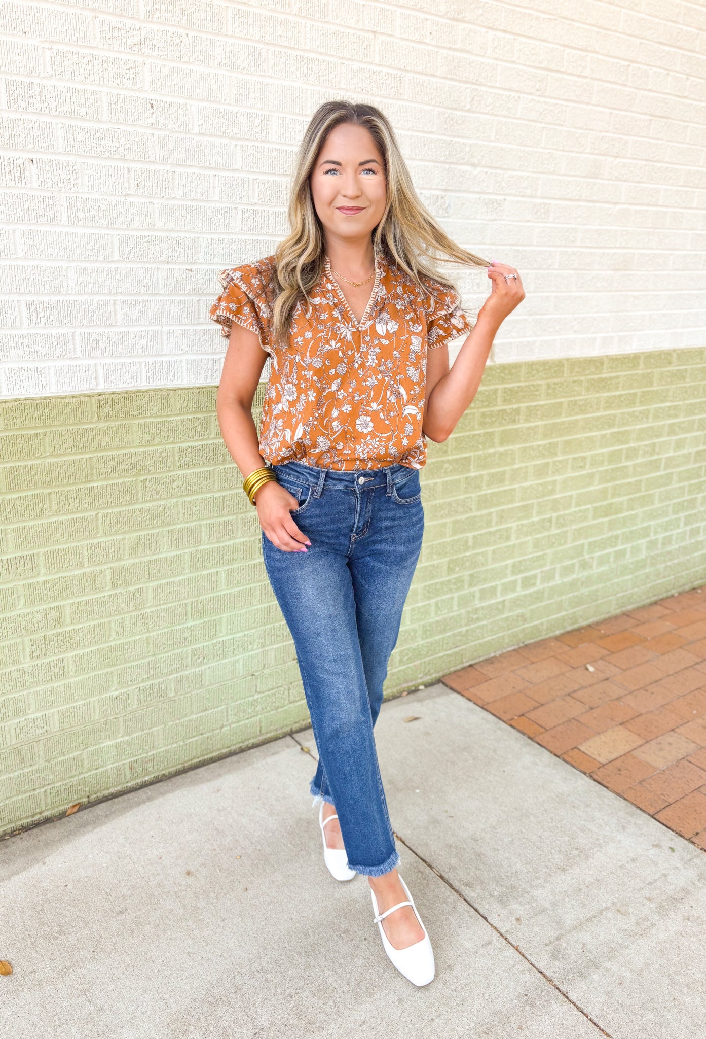 Calling Again Floral Blouse, mustard ruffle sleeve blouse with v-neck and off white floral print, off white whip stitching on the hem of the ruffles on the sleeves, and on the neck line