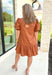 Caught Crushing Dress in Caramel, puff sleeve dress with smocked v-neck line and smocking on the hem of the sleeve, tier detail on the bottom hem of the dress 