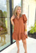 Caught Crushing Dress in Caramel, puff sleeve dress with smocked v-neck line and smocking on the hem of the sleeve, tier detail on the bottom hem of the dress 