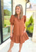 Caught Crushing Dress in Caramel, puff sleeve dress with smocked v-neck line and smocking on the hem of the sleeve, tier detail on the bottom hem of the dress 