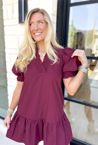 Caught Crushing Dress in Merlot, puff sleeve dress with smocked v-neck line and smocking on the hem of the sleeve, tier detail on the bottom hem of the dress 