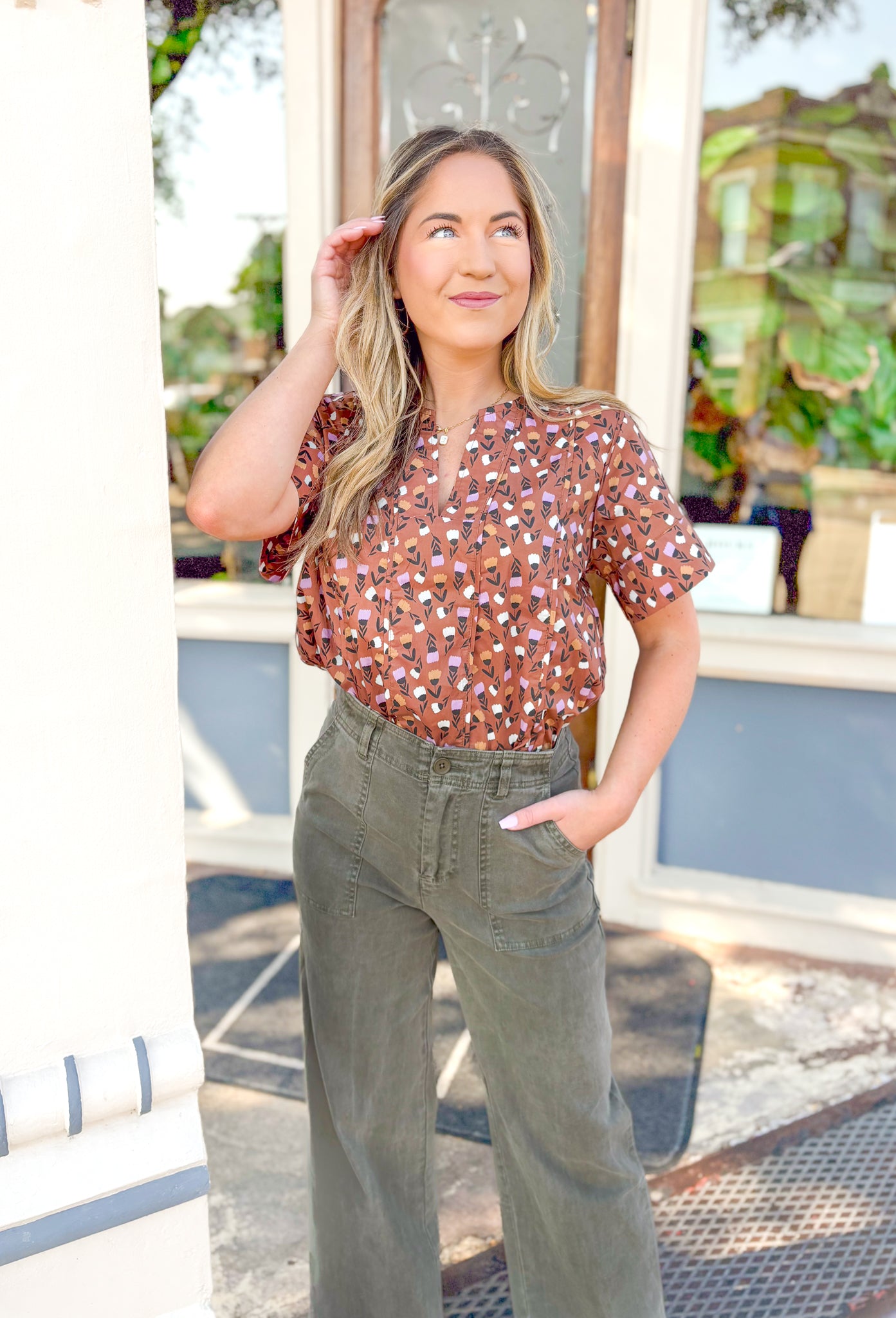 Closer Than Ever Floral Top, warm brown short sleeve blouse with cream, orange, and light purple tulips, blouse has a v-neck line 