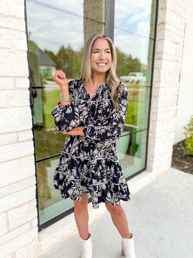 Dream About It Floral Dress, black, taupe, and white long sleeve tiered floral dress with v-neck line, grey and white horizontal stripe piping on the tiers and neck line