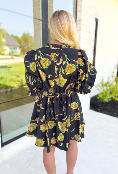 Glimpse Of Us Floral Dress, black, yellow, and green floral quarter button down puff sleeve dress with pleating on the collar and sleeves, tie detail on the back of the dress 