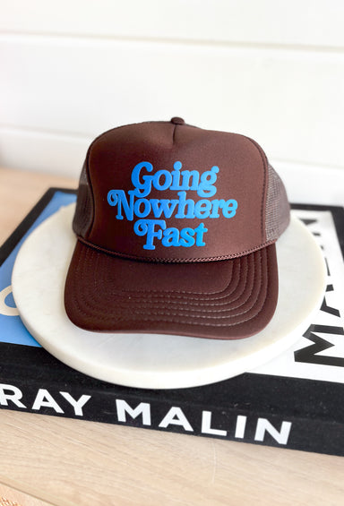 Going Nowhere Fast Trucker Hat in Brown, brown trucker hat with blue text "going nowhere fast" in the center 