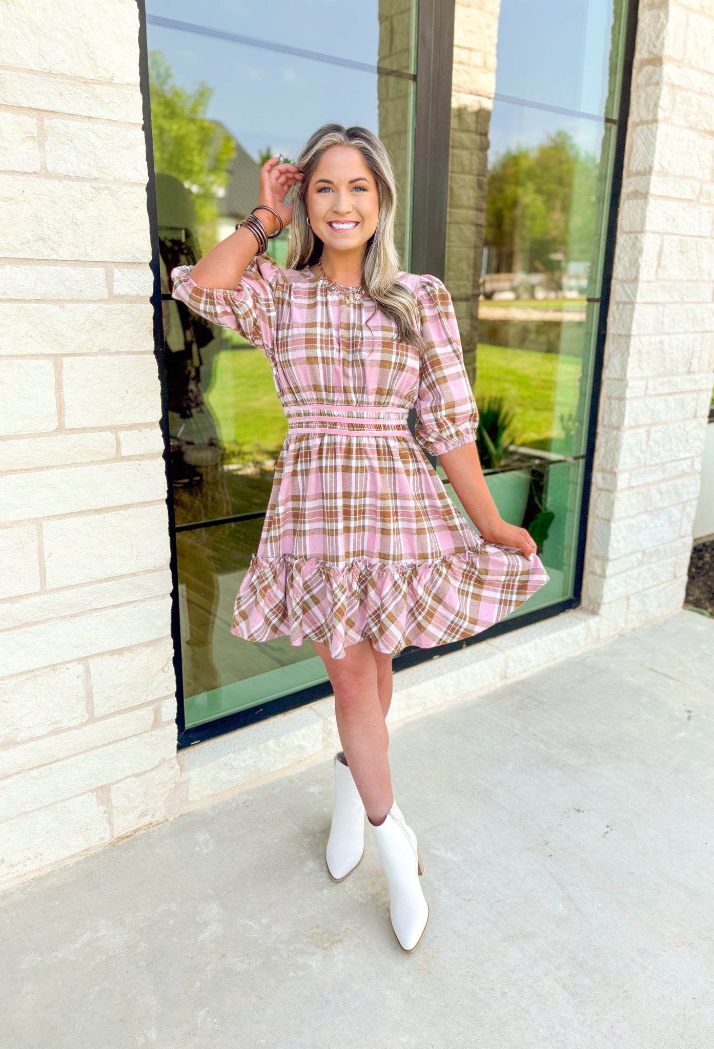 Heading South Plaid Dress, light pink, cognac, and off white plaid puff sleeve mini dress with cinching at the waist with light pink velvet details layered on top of the cinching, tier on the bottom of the dress with ruffle hem detail 