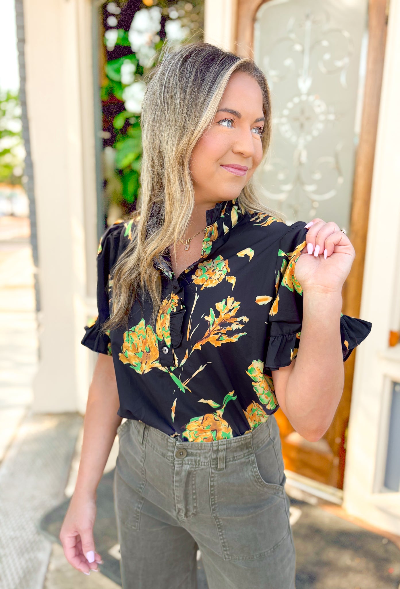 Lost In Time Floral Top, black puff sleeve blouse with ruffling on the hem of the sleeves and neck, quarter button down detail, black blouse with yellow and green floral details 