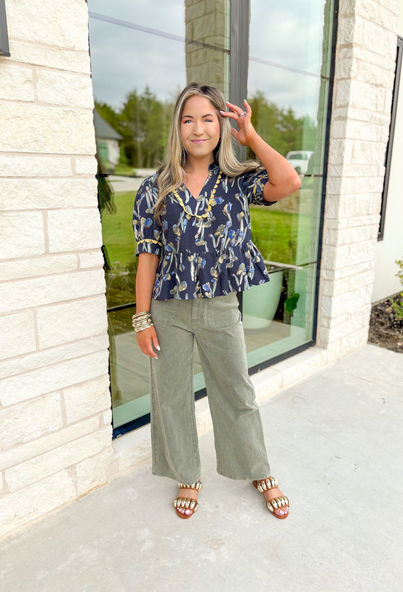 More Than Enough Top, faded navy cropped puff sleeve blouse with v-neck line, abstract tulip detail in sage, blue, and brown, lime scalloping detail on the neck line and on the sleeves