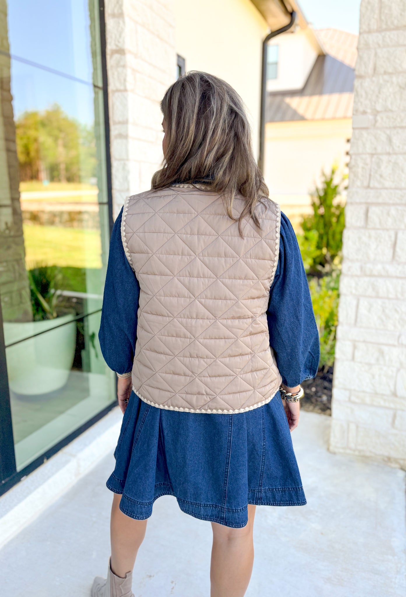 Mountain Side View Quilted Vest, tan quilted vest with cream whipstitching on the hem of the vest, snap button closure, pockets 