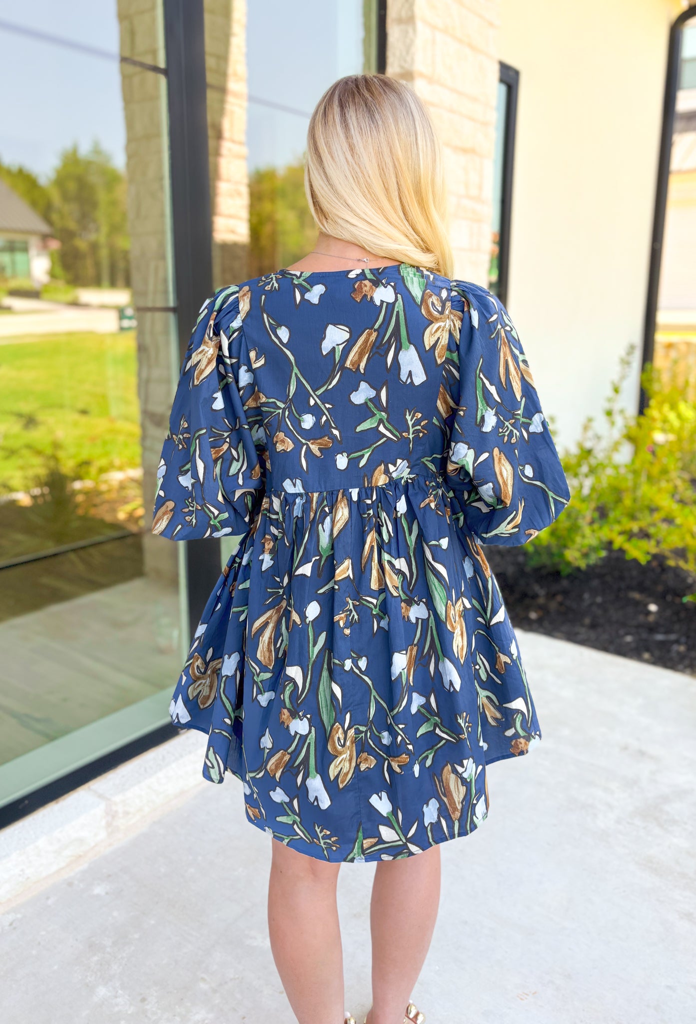 Nashville Stroll Floral Dress, deep blue/deep teal quarter puff sleeve baby doll dress with a v-neck line. Green, light blue, cream, taupe, and cognac abstract tulips all over the dress 