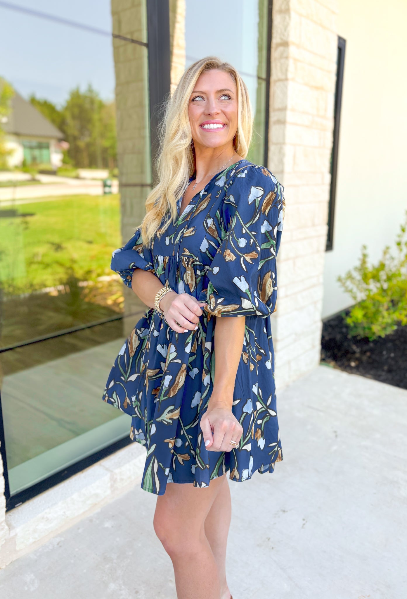 Nashville Stroll Floral Dress, deep blue/deep teal quarter puff sleeve baby doll dress with a v-neck line. Green, light blue, cream, taupe, and cognac abstract tulips all over the dress 