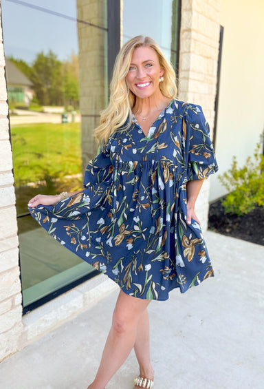 Nashville Stroll Floral Dress, deep blue/deep teal quarter puff sleeve baby doll dress with a v-neck line. Green, light blue, cream, taupe, and cognac abstract tulips all over the dress 