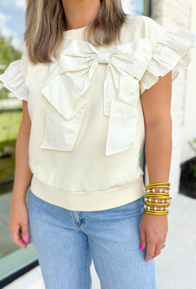 No Second Chances Top, bright cream ruffle sleeve blouse with large bow on the top left side of the chest