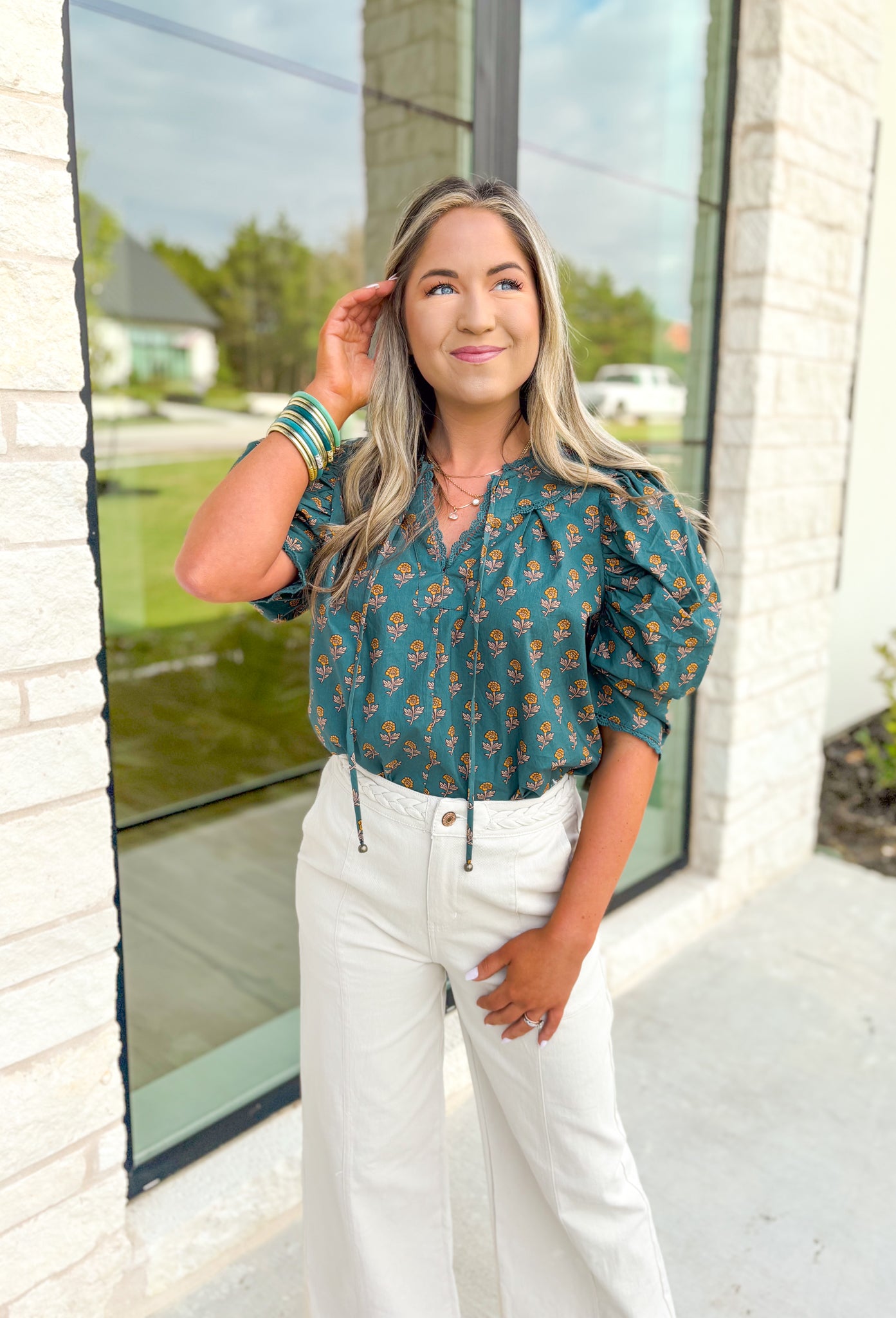 Off The Record Floral Top, blue green puff sleeve blouse with v-neckline, yellow and tan floral detail, lace on the neck line, around the collar, and on the hem of the sleeves 