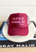 Husbands Tab Trucker Hat, maroon trucker hat with bubble gum pink text on the front "put it on my husbands tab! (thanks!)"