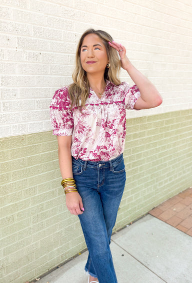 Roaming Rome Floral Blouse, short sleeve plum and off white floral blouse with collar, v-neck, and plum scalloped lace across the chest and around the center of the puff sleeve