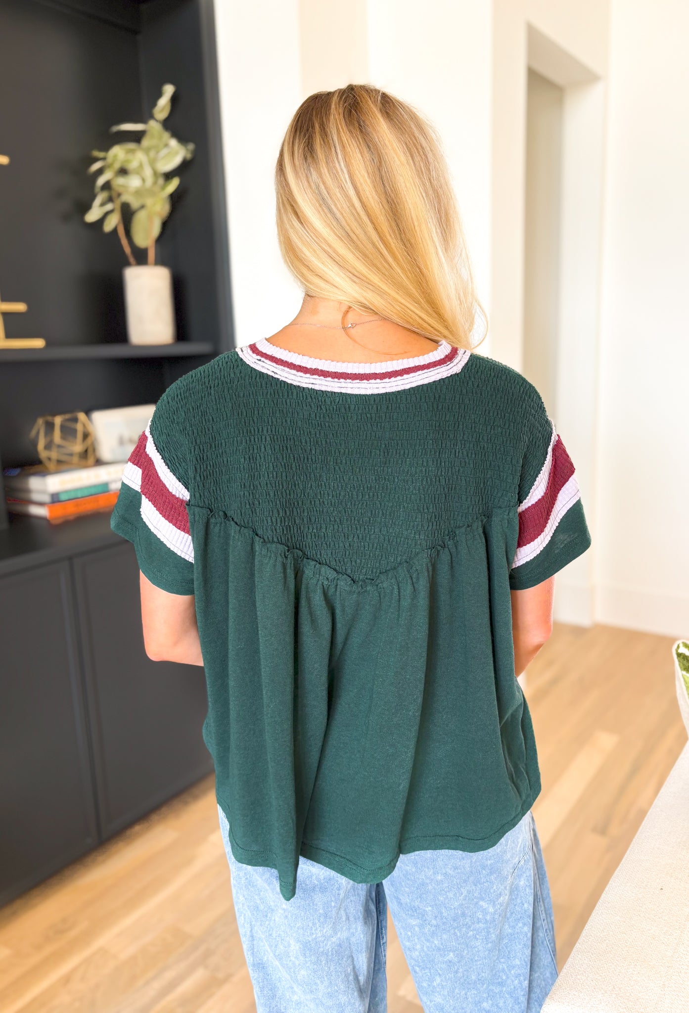 See For Yourself Top, forest green short sleeve top with smocking across the chest and shoulders, maroon and pale lilac stripes on the sleeves and neck